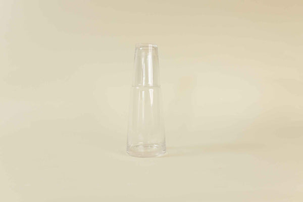 Clear drinking glass and clear glass water carafe filled with water 