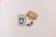 Closeup view of set of three glittery enamel pins, a pink heart with a yellow taxi, a small pigeon, and a coffee cup that reads Caffeine Addict