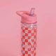 Clear acrylic water bottle with red checkerboard pattern, free floating glitter, and pink lid with folding straw, made by Golden Gems