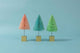  Zoomed out view of set of three squat pink, blue, and mint green sisal decorative trees mounted on metallic gold wood base