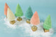 Zoomed out view of six pastel sisal decorative trees mounted on metallic gold wood base