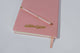 Blush pink vegan leather notebook with gold phrase FEMINIST AGENDA in metallic gold, back of notebook features gold Golden Gems logo