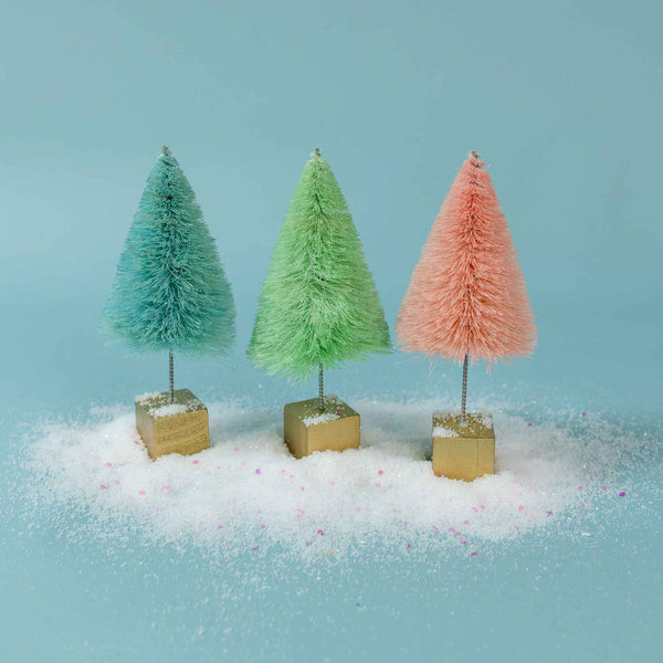 Close up view of set of three squat blue, mint green, and pink sisal decorative trees mounted on metallic gold wood base
