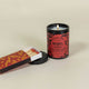 Lit Dark Tobacco and vanilla scented candle in black jar with red snake-pattern label, 12 ounce jar with matching set red and gold matches